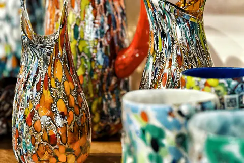 Jarrones de vidrio de Murano de colores sobre una mesa de madera